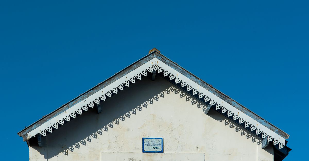 Fachada antigua de una casa con molduras y balcón de hierro